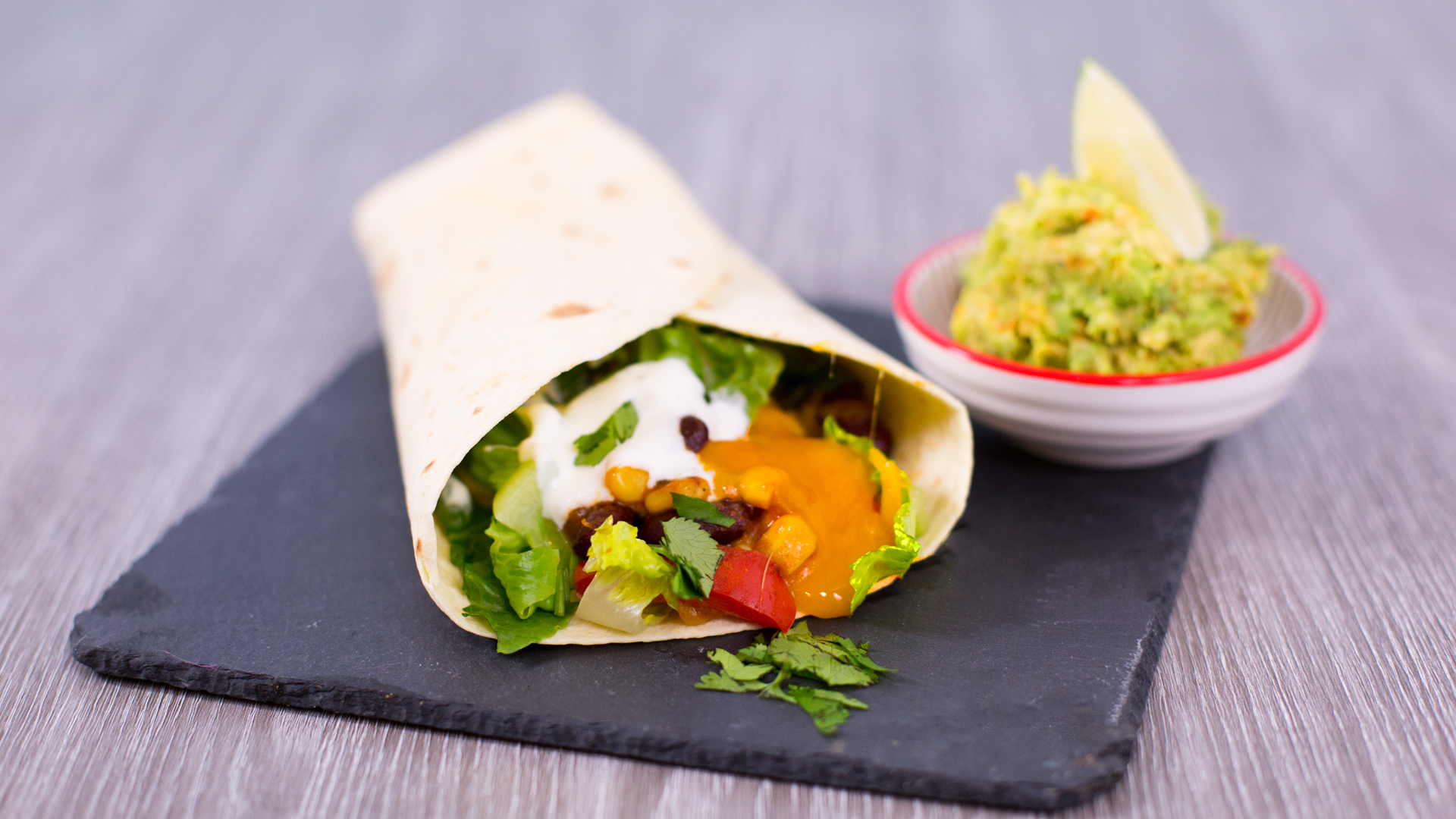 Vegetarischer Burrito mit Bohnen, Salat und AvocadoDip